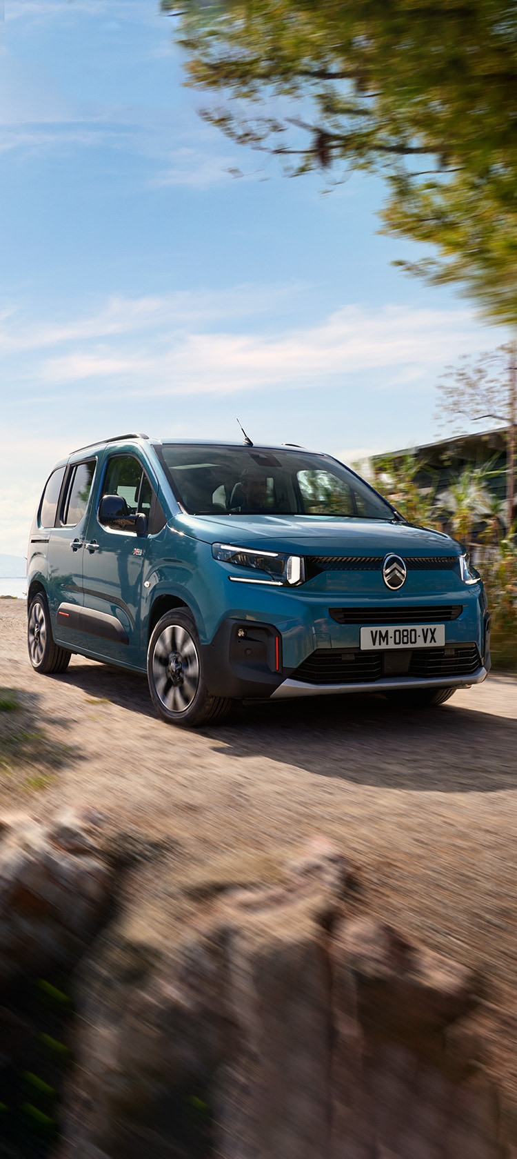 Blue ë-Berlingo drive on roads by the sea